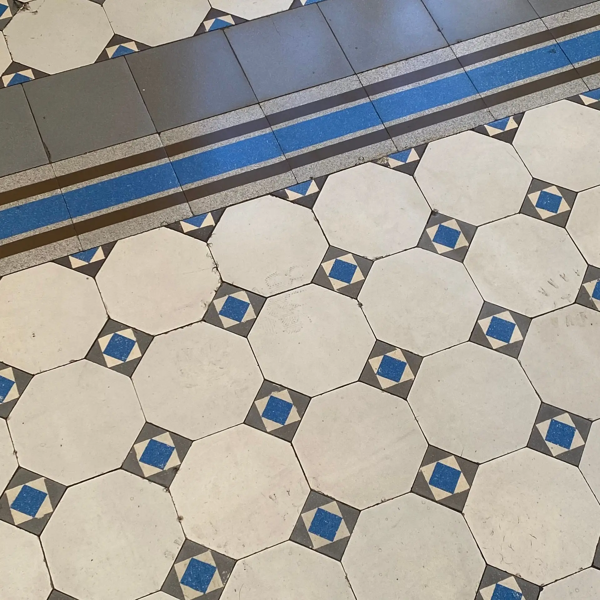 Suelo de mosaico hidráulico con octógonos blancos y estrellas azules
